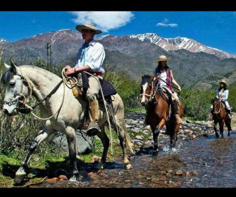 two people riding horses down a dirt road at CABAÑA.Manzano histórico. Paz y montaña in Tunuyán