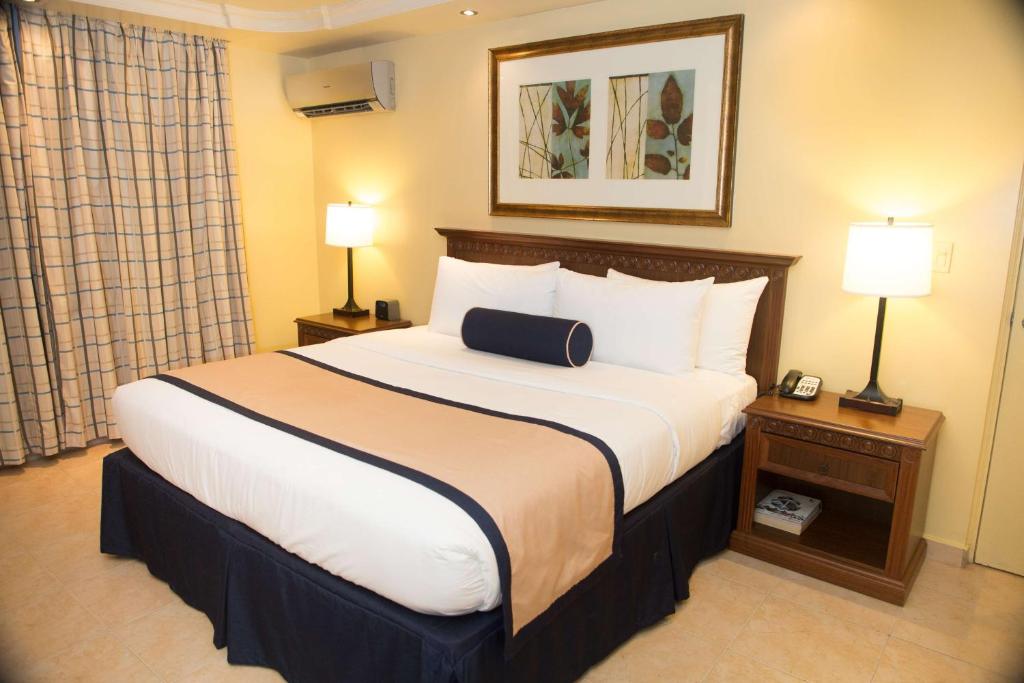 a large bed in a hotel room with two lamps at Best Western El Dorado Panama Hotel in Panama City