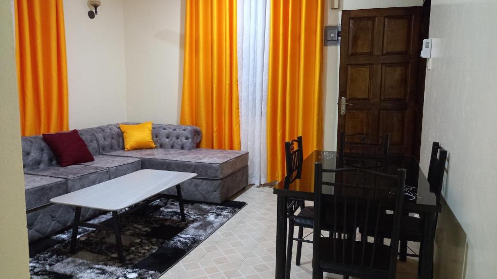 Joly Apartments, Nyali Mombasa في مومباسا: غرفة معيشة مع أريكة وطاولة