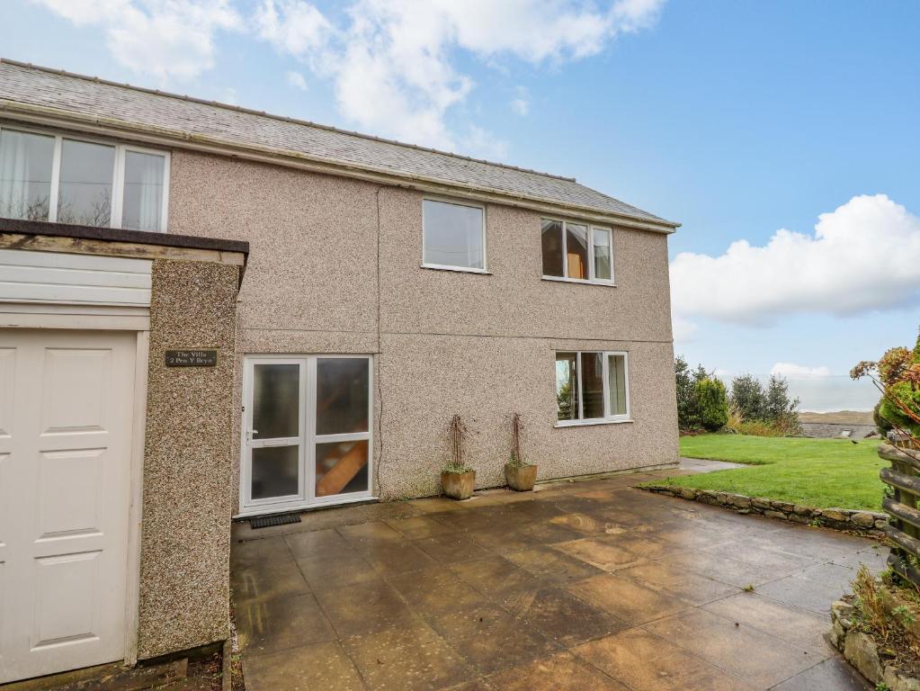 a brick house with a white garage at The Villa in Harlech