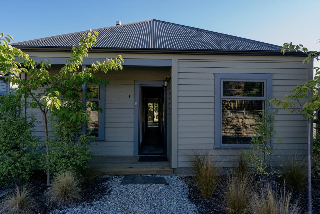 a small house with a porch and a door at Cardrona Valley Escape - Cardrona Holiday Home in Cardrona