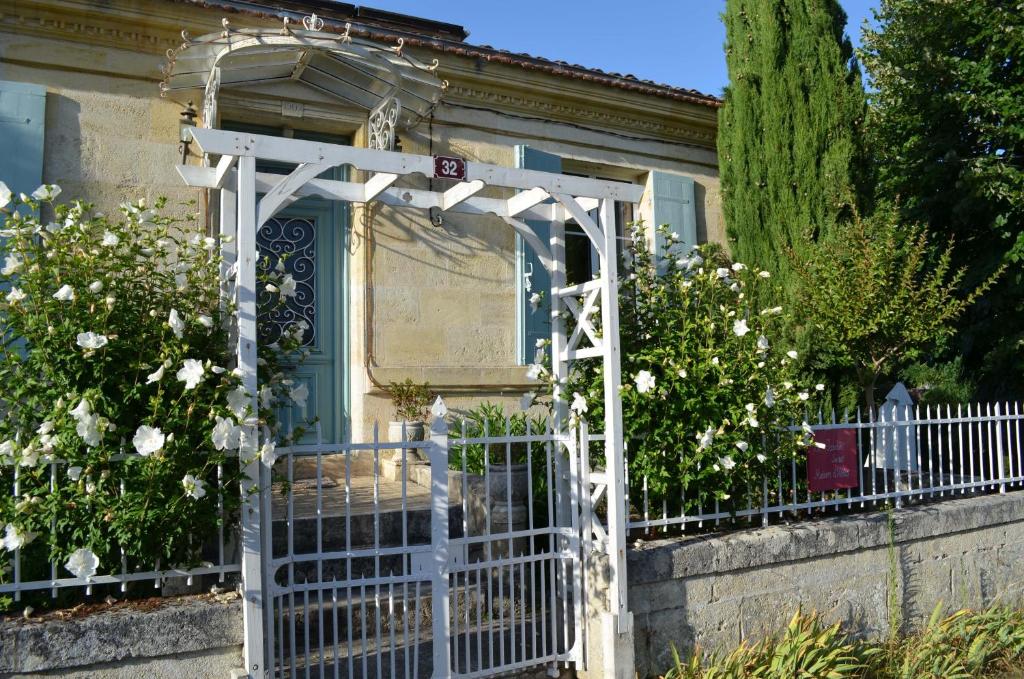 une porte en face d'une maison fleurie dans l'établissement Le Jardin Secret, à Gauriac