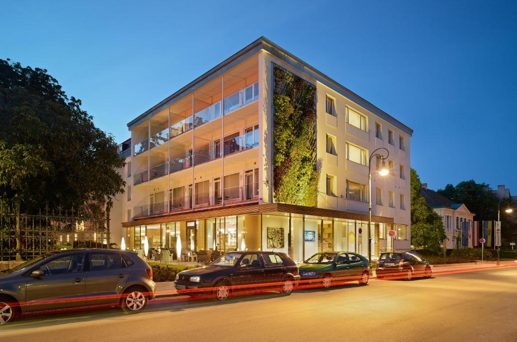 a building with cars parked in front of it at At the Park Hotel in Baden