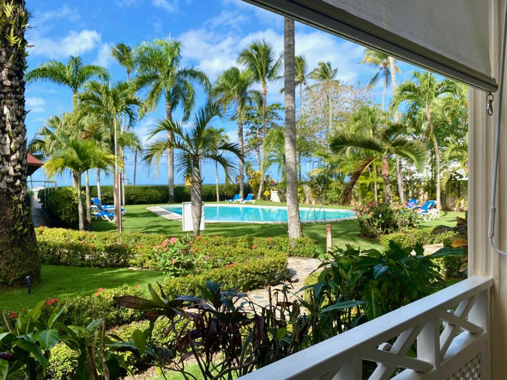 een balkon met uitzicht op het zwembad van een resort bij La Dolce Vita Beachfront Apt 2 in Las Terrenas