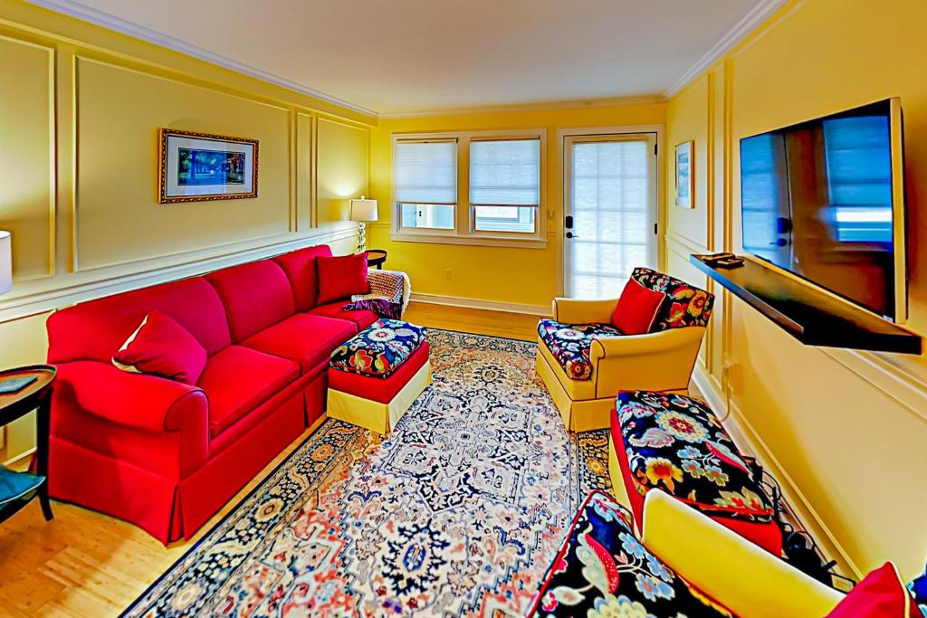 uma sala de estar com um sofá vermelho e cadeiras em Hiawassee W203 em Asheville