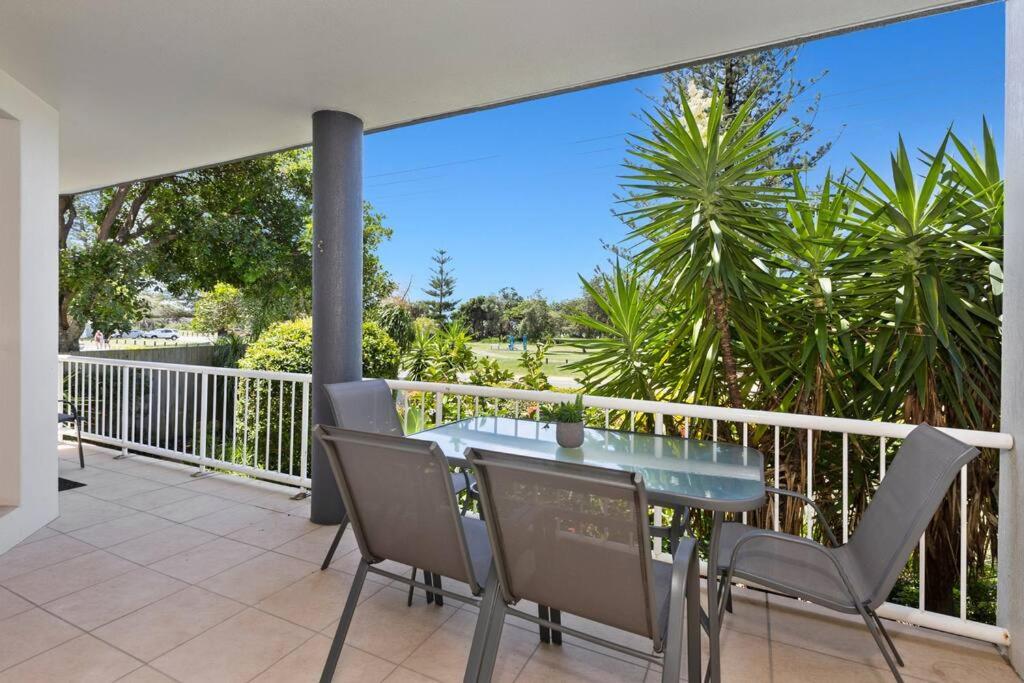 a patio with a glass table and chairs on a balcony at 2Bed Beachfront Apartment - Holiday Management in Kingscliff