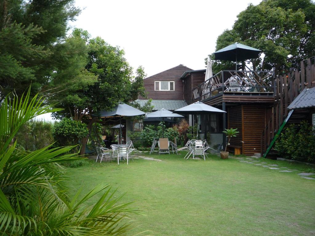 a yard with chairs and tables and umbrellas at Share B&B in Puli