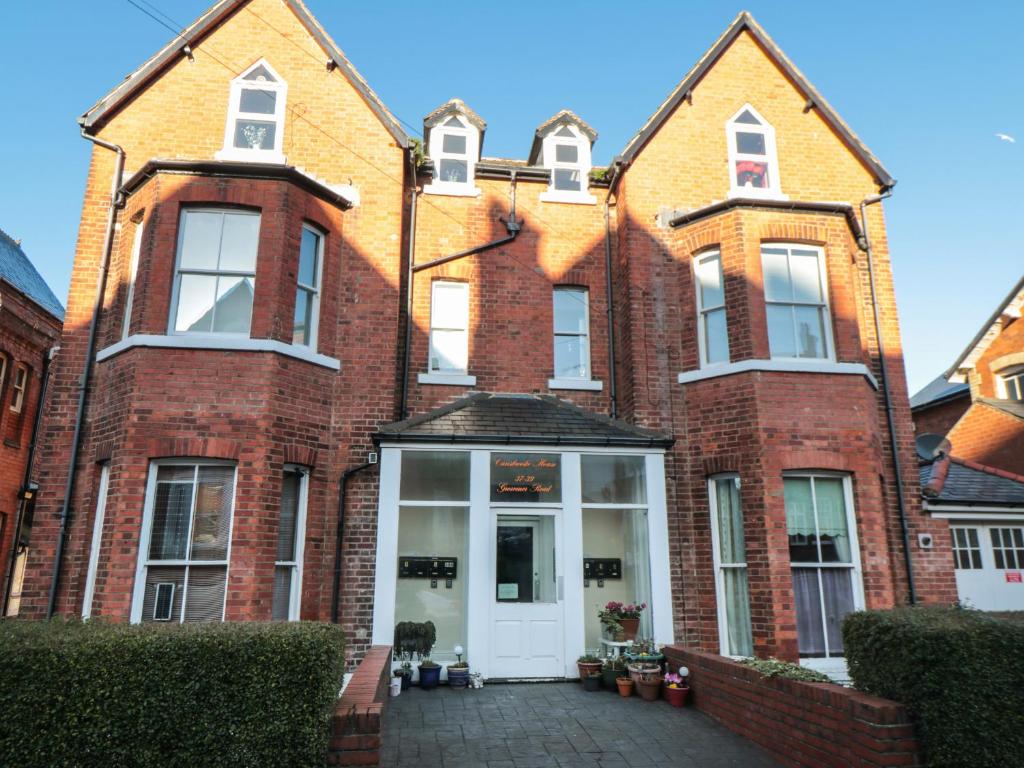 um grande edifício de tijolos com uma porta branca em Carisbrooke House, Apartment 6 em Scarborough