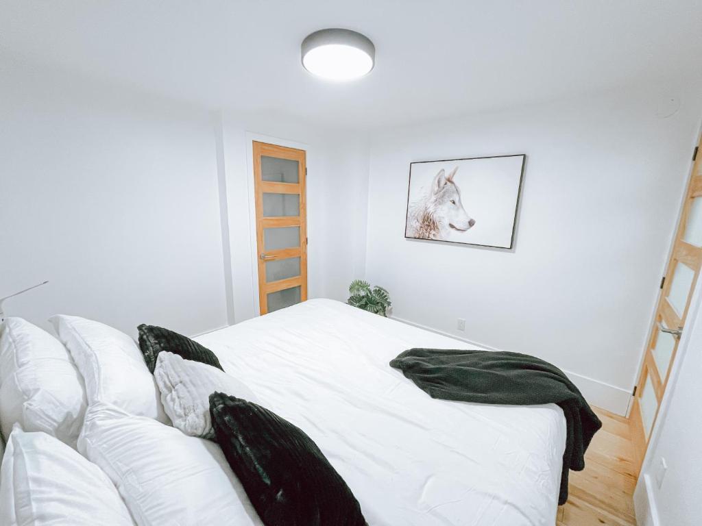 a bedroom with a white bed and a couch at Complexe LIVTremblant by Gestion ELITE - LIV6 in Mont-Tremblant