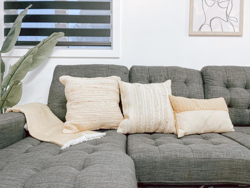 a gray couch with pillows on it in a living room at Complexe LIVTremblant by Gestion ELITE - LIV6 in Mont-Tremblant