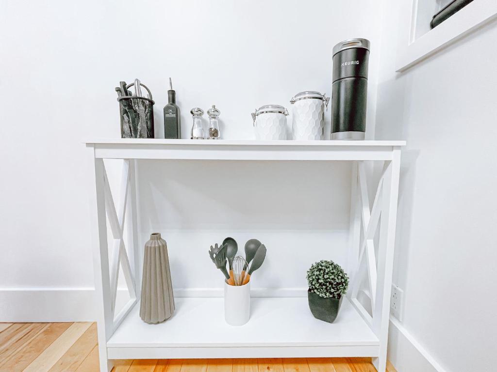 a white shelf with plants and vases on it at Complexe LIVTremblant by Gestion ELITE - LIV6 in Mont-Tremblant