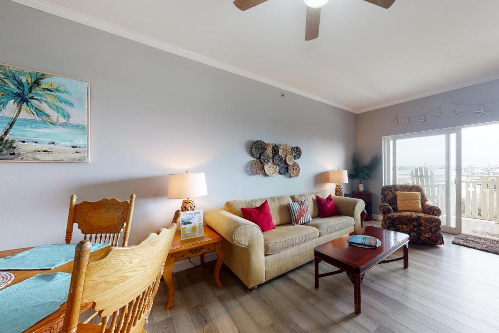 a living room with a couch and a table at Waterside Village 406 - Isle of View More in Mexico Beach