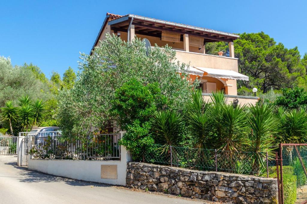 una casa con una recinzione e piante di fronte ad essa di Apartments Namoru Gradina a Vela Luka (Vallegrande)