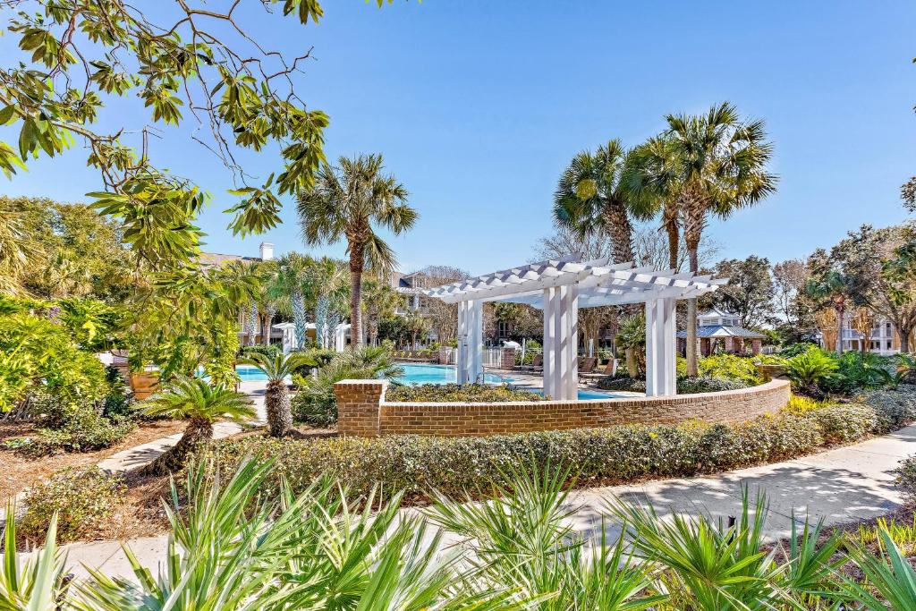 a garden with a gazebo and a pool at Salty Escape in Destin