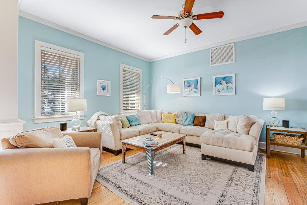 a living room with couches and a ceiling fan at Tradewinds in Folly Beach