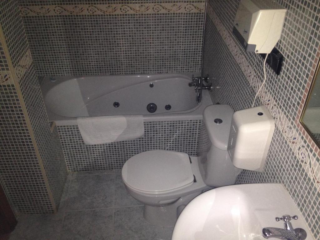 La salle de bains est pourvue de toilettes et d'une baignoire. dans l'établissement Café Bar Hotel Jefi, à Jaraiz de la Vera