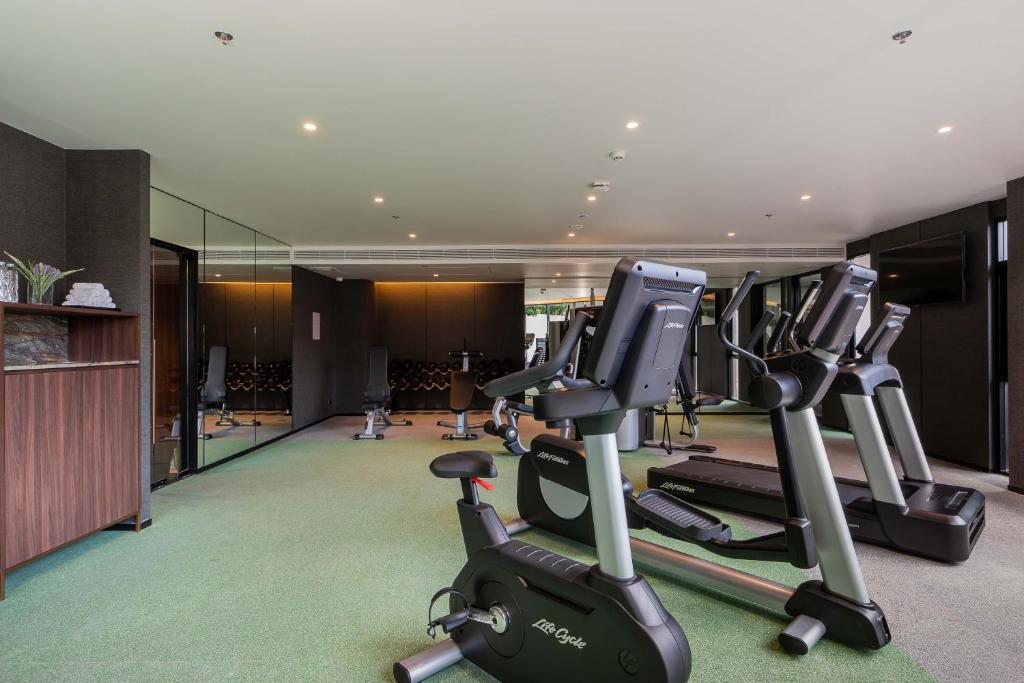 A compact fitness room with treadmills, a stationary bike and other cardio equipment.