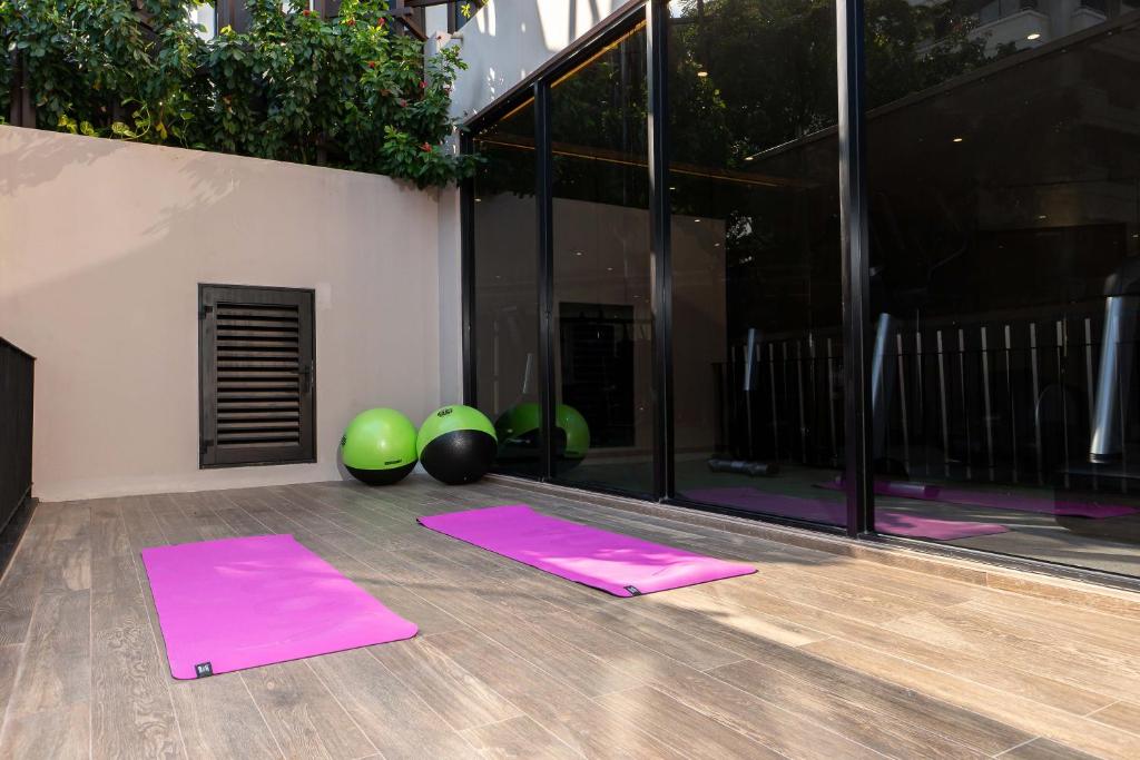 An outdoor fitness corner with pink exercise mats and mirrored studio doors.