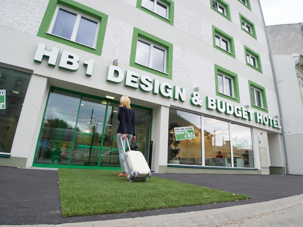 a woman with a suitcase in front of a building at HB1 Schönbrunn Budget & Design in Vienna