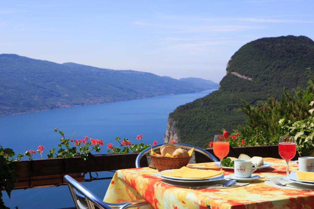 een tafel met een mand met eten en wijnglazen bij Hotel Panorama e Residence in Tremosine Sul Garda