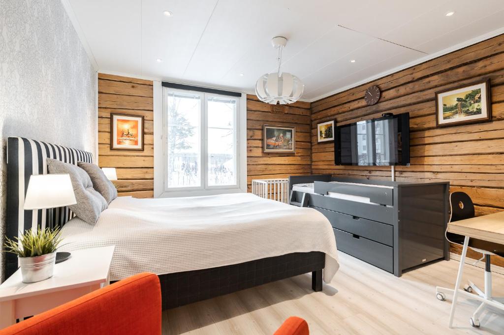 een slaapkamer met een bed, een wastafel en een tv bij Villa Härmälä in Tampere
