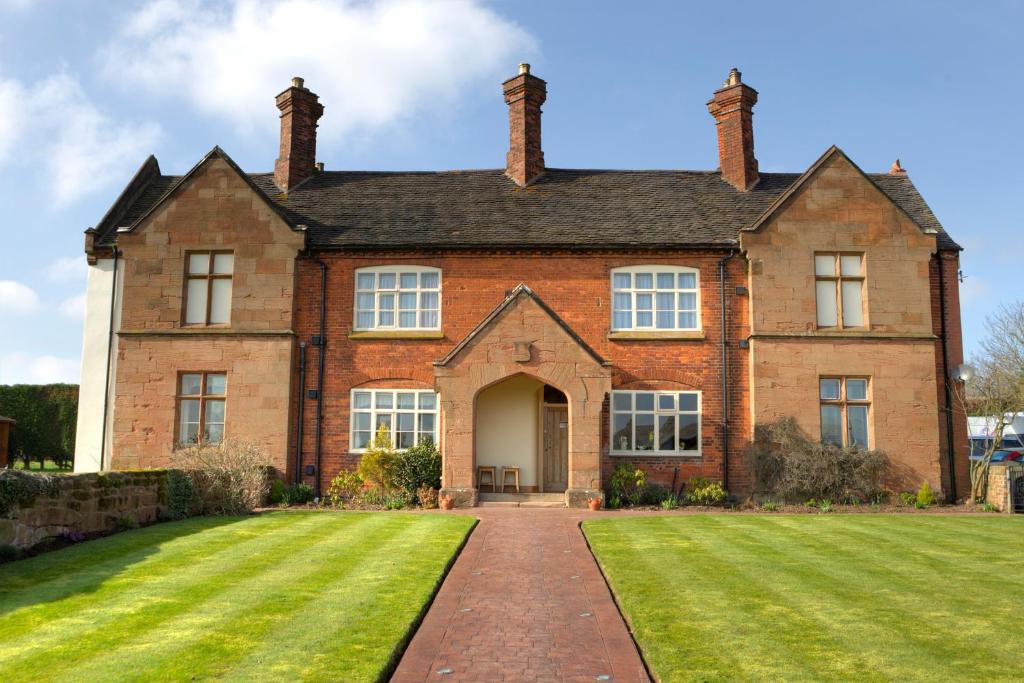 an old brick house with a lawn in front of it at Old Hall House, NEC in Meriden