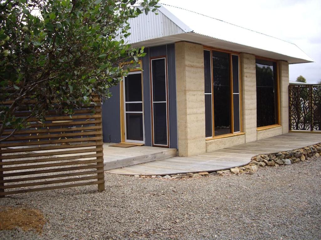une petite maison avec une terrasse couverte et une clôture dans l'établissement Wedgetaildown, à Parndana