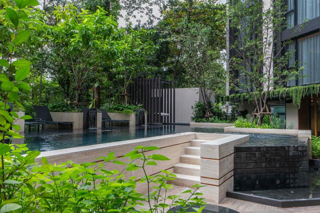 A garden pool beside a raised waterfall feature and steps.