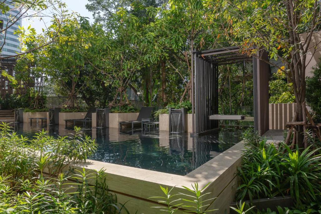 A garden swimming pool with built-in waterfalls and shaded seating.