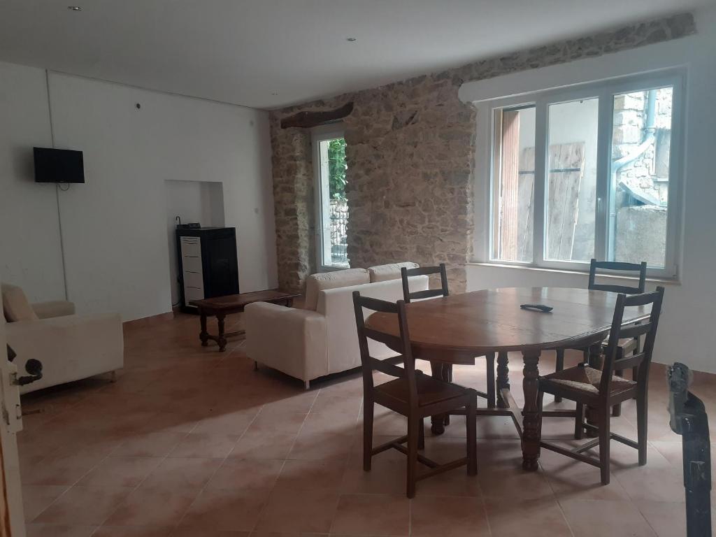 ein Wohnzimmer mit einem Tisch, Stühlen und einem Sofa in der Unterkunft Appartemment situé a lacaune les bains in Lacaune