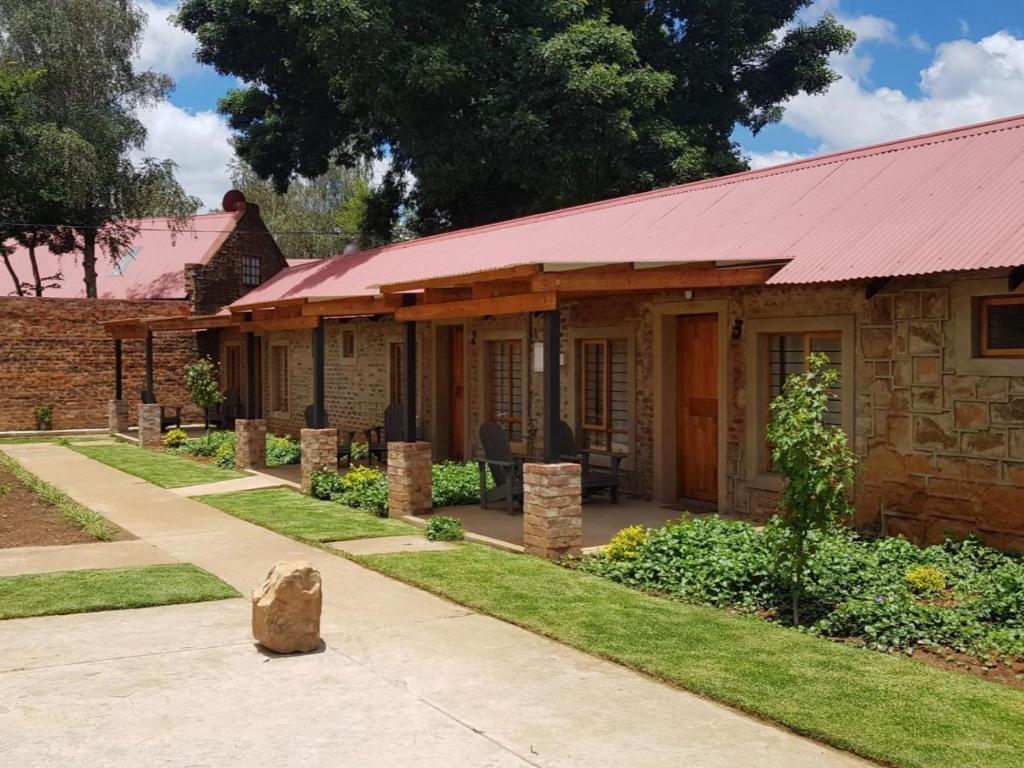 a stone house with a red roof at The Stables At Critchley in Dullstroom