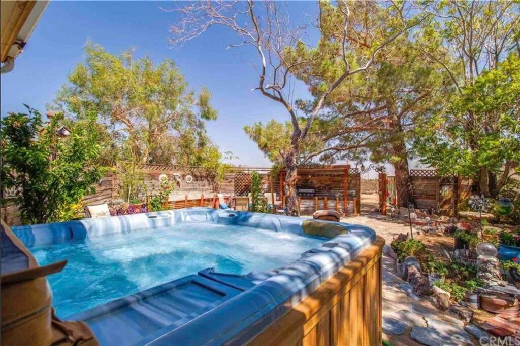 a swimming pool in a backyard with a wooden fence at Lunar Eclipse on 4 acres w hot tub in Yucca Valley