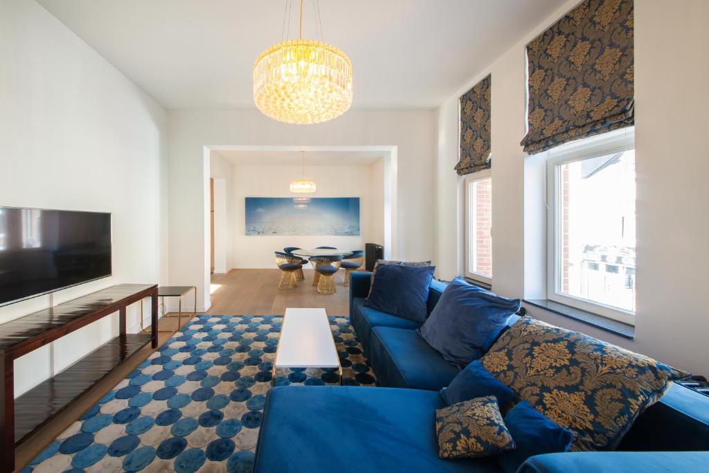een woonkamer met een blauwe bank en een tv bij Residentie Nevejan in Kortrijk