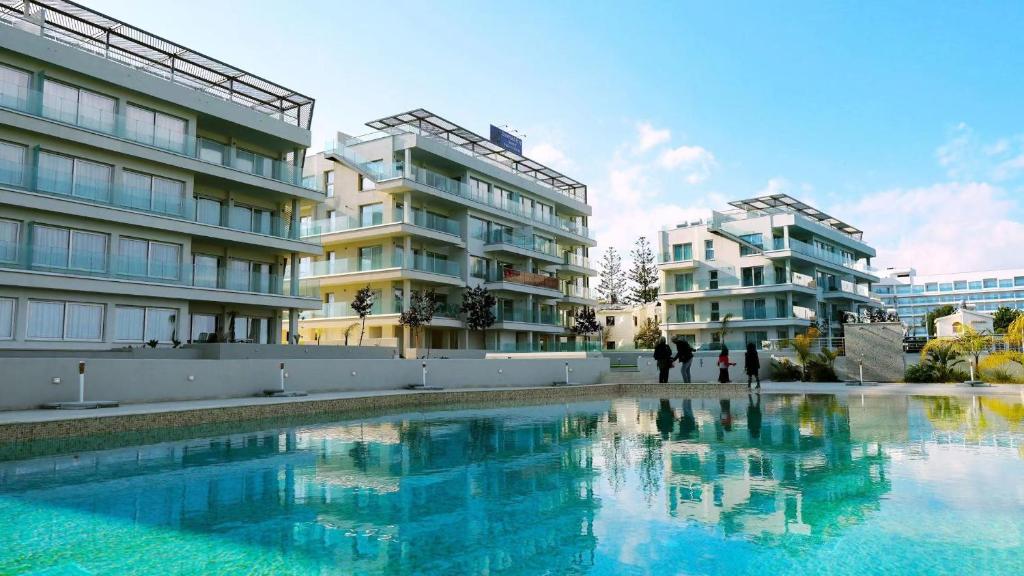 a large swimming pool in front of two buildings at Emerald Suites in Protaras