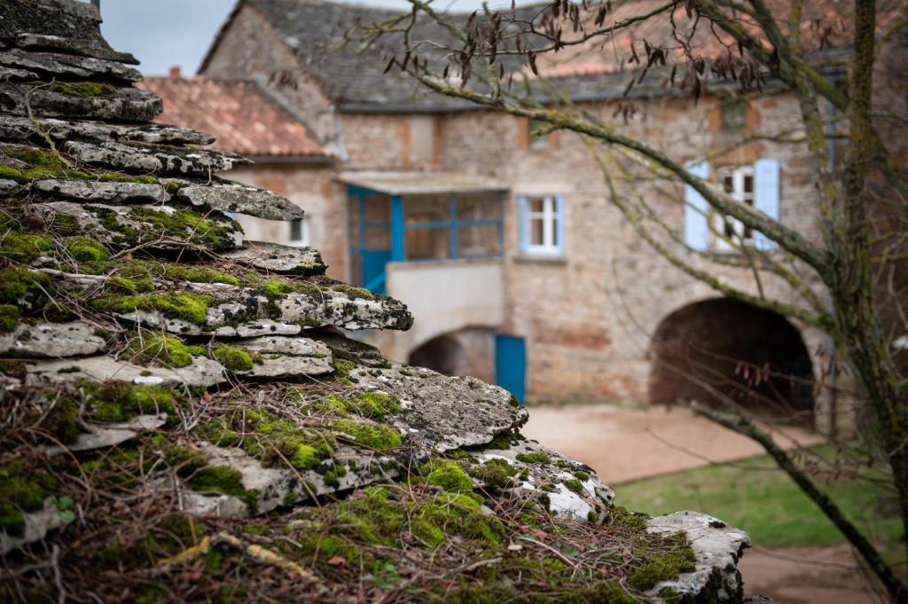 eine alte Steinmauer mit einem Haus im Hintergrund in der Unterkunft Gîte de Grailhes in Aguessac