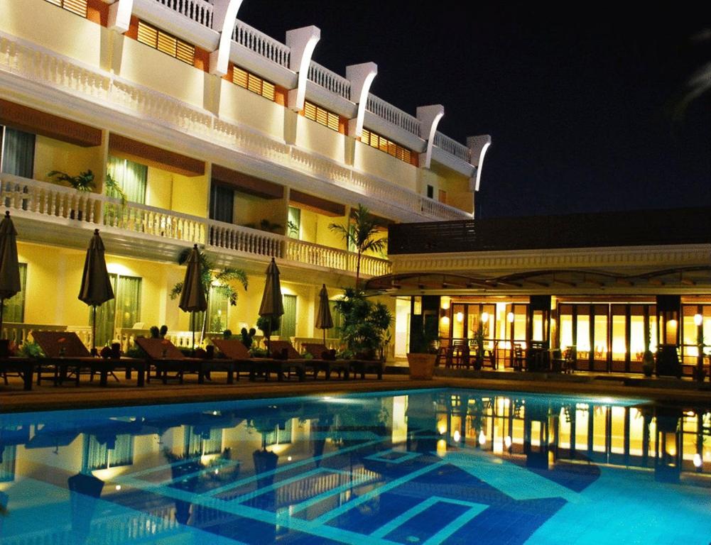 a hotel with a swimming pool in front of a building at Windmill Resort Hotel Pattaya in Pattaya North