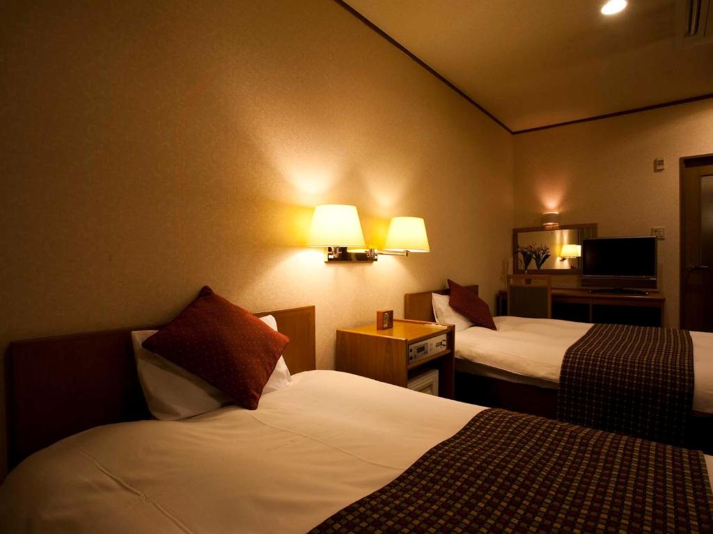 Postel nebo postele na pokoji v ubytování Dogo Prince Hotel