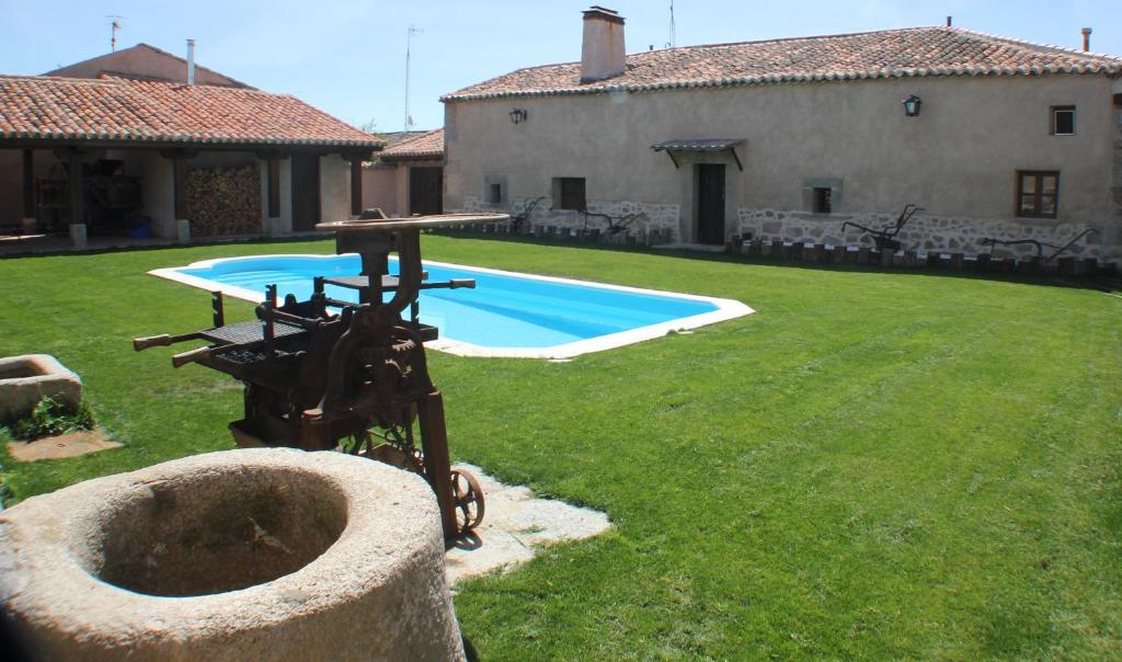 a yard with a swimming pool and a house at Casa Rural La Centenaria de Alaraz 