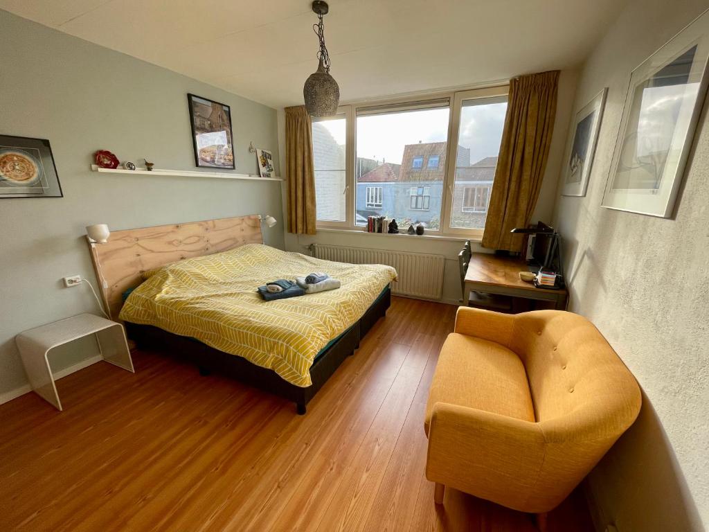 a bedroom with a bed and a chair at Comfortable Room in Alkmaar