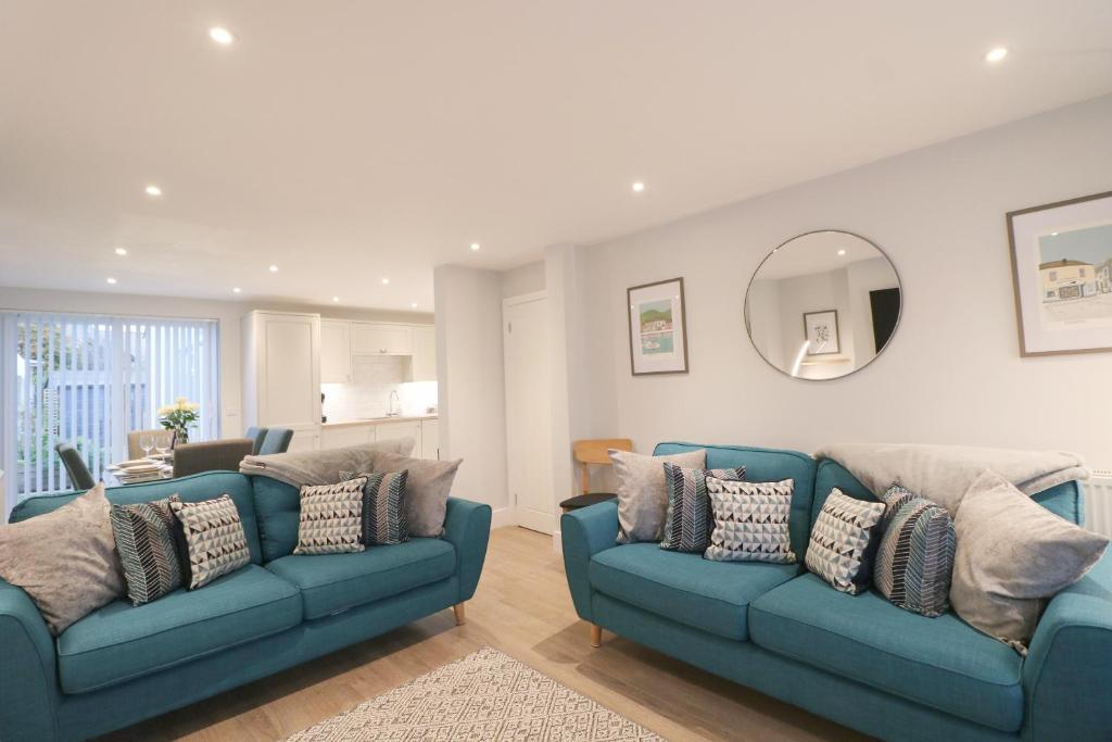 a living room with two blue couches and a mirror at Townhouse, close to harbour with sea views in Padstow