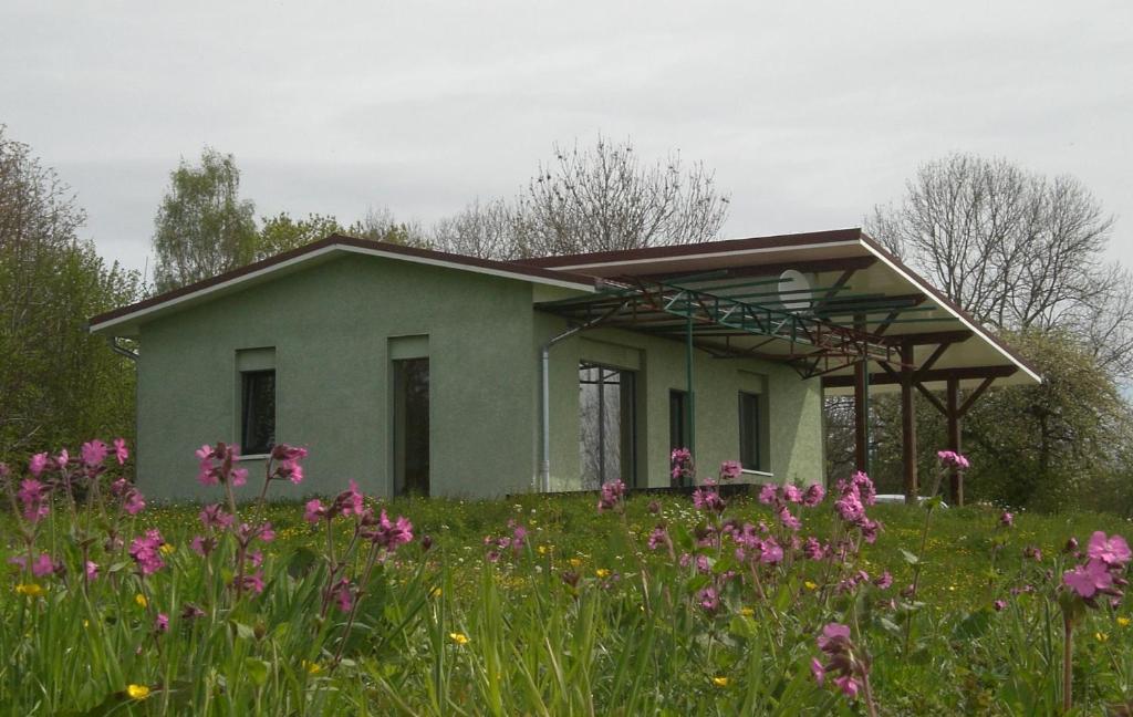 a house with a field of flowers in front of it at Gîte Le Chant des Cloches in Fleurey