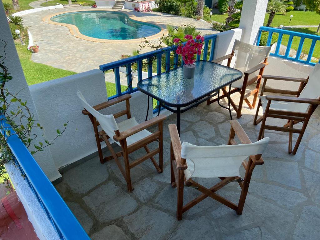 un patio con tavolo, sedie e piscina di Minimal Resort with Pool in Siviri, 150m from the Sea a Siviri