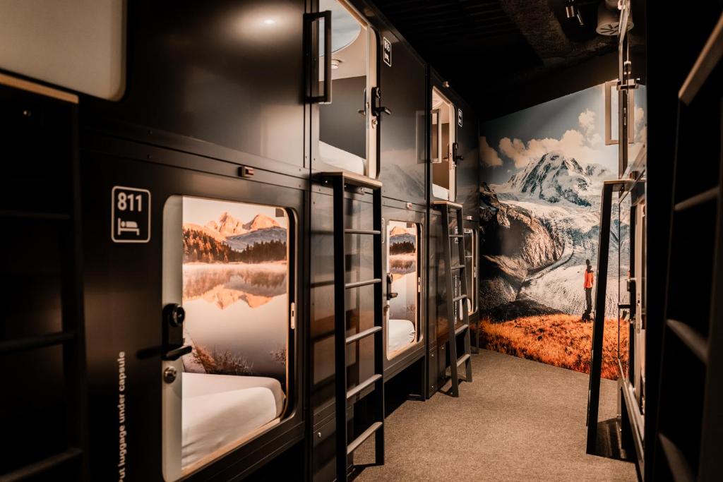 a corridor of a train with paintings on the walls at Capsule Hotel - Alpine Garden Zurich Airport in Kloten