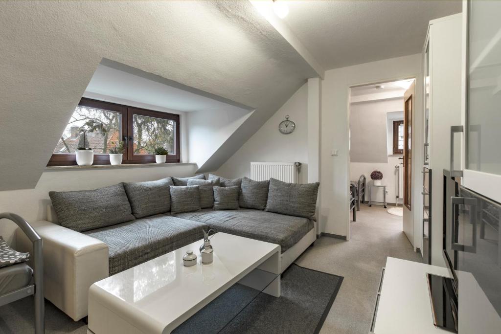 ein Wohnzimmer mit einem Sofa und einem Tisch in der Unterkunft Ferienwohnung-Fuhlsbüttel-Hamburg in Hamburg