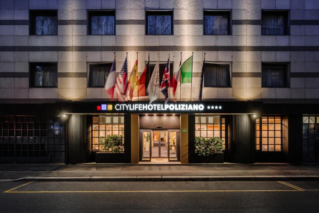 a building with flags on the front of it at City Life Hotel Poliziano, by R Collection Hotels in Milan
