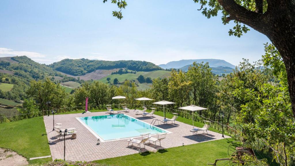 卡伊的住宿－Ca' Paolo 8, Emma Villas，一个带椅子和遮阳伞的游泳池,享有山景