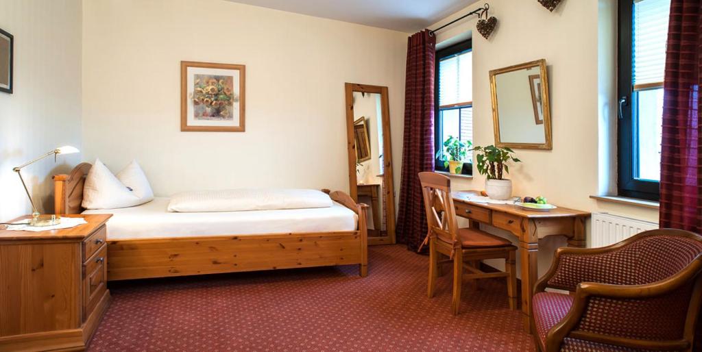 a hotel room with a bed and a desk and a desk at Gasthof Sauerteig in Rödental