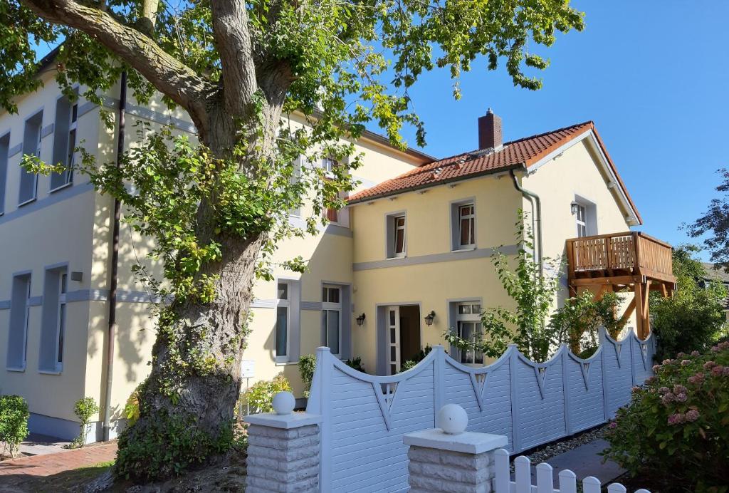einen weißen Zaun vor einem Haus in der Unterkunft Ferienwohnung Villa im Park in Wangerooge