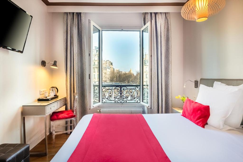 pokój hotelowy z łóżkiem i oknem w obiekcie Hotel Eiffel Segur w Paryżu