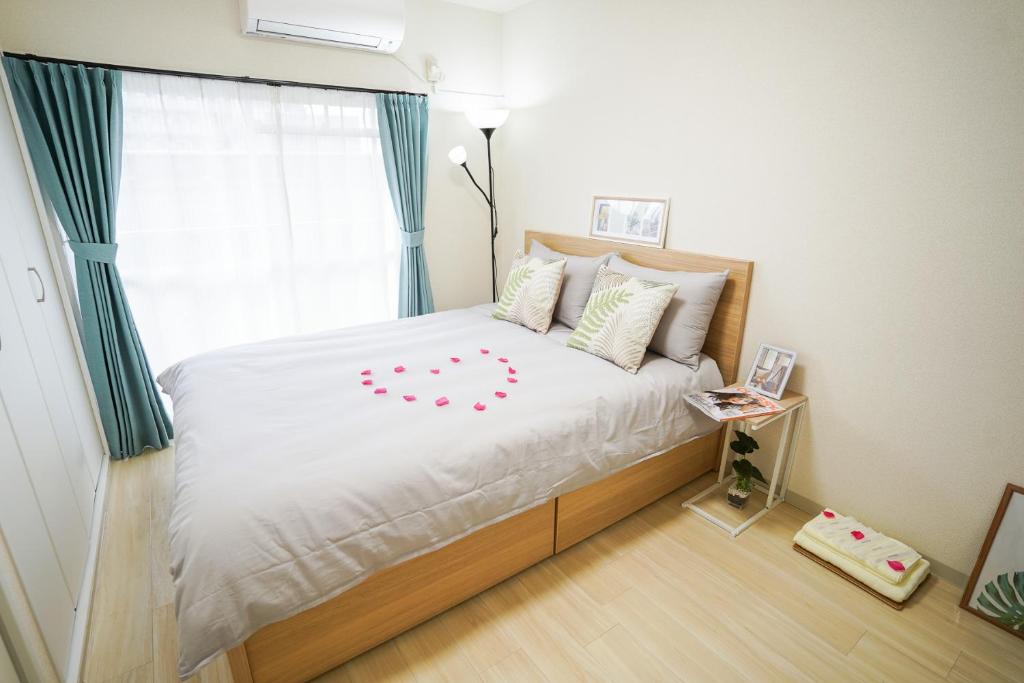 1 dormitorio con 1 cama con sábanas blancas y ventana en stay's サンジョイフル 303号 名古屋 民泊 駅近 en Nagoya